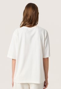 Hvid bomulds t-shirt med korte ærmer, afslappet pasform, rund halsudskæring og subtil broderet detalje på venstre ærme.