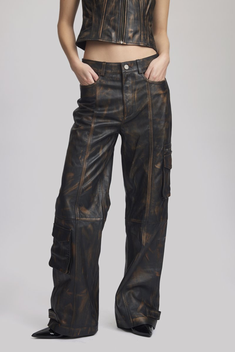 Black and brown leather cargo pants with a high waist, wide legs, stitched details, and side pockets. Textured finish with a distressed look.