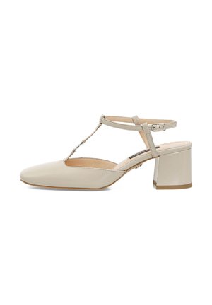 Scarpa slingback in pelle sintetica beige con punta quadrata e tacco a blocco. Presenta una fascia a T e una fibbia regolabile per una vestibilità sicura.