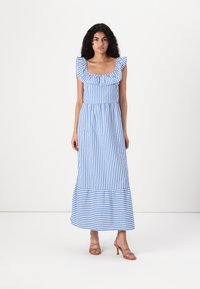 Maxikjole i blå og hvide striber, med en flæset halsudskæring, tætsiddende talje og en flagrende bund. Stoffet er let og struktureret.