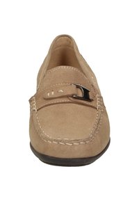 Mocassins beige en daim avec un bout arrondi, une bride décorative, des éléments métalliques argentés et des détails cousus le long des bords. Semelle plate en caoutchouc.