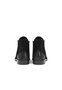 Botines de ante negro con un acabado de piel suave, cremalleras laterales y un tacón bajo y robusto. Diseño simple con líneas limpias y sin adornos.