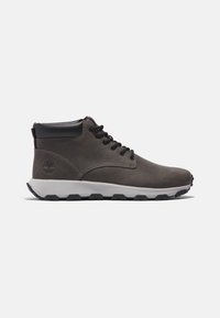 Mid-height brown leather boots with a smooth texture, black accents, round toe, and a white sole featuring a textured grip pattern.