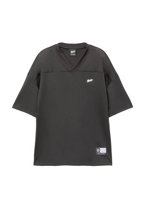 Sort mesh t-shirt med korte ærmer og V-udskæring, der har et lille logo på brystet og etmærke på den nederste søm. Åndbart stof.
