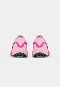 Hardloopschoenen in lichtroze met zwarte accenten. Getextureerde bovenkant, gevoerde hiel en dikke rubberen zool met roze details en een profielontwerp.