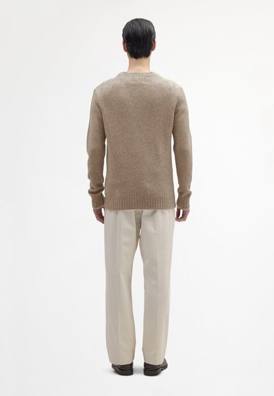 Beige wollen trui met een gestructureerde afwerking, geribbelde manchetten en zoom, met een klassieke ronde halslijn en lange mouwen.