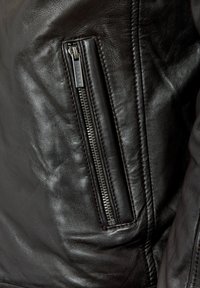 Zwarte leren jas met een ritssluiting aan de linkerkant, met een gladde textuur en gedetailleerde stiksels langs de naden.