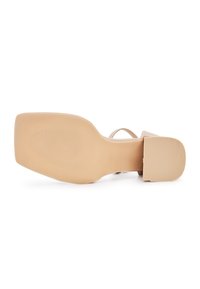 Sandale à talon haut beige avec un bout carré et un talon épais. Texture lisse avec une semelle extérieure striée pour une traction optimale. Design minimaliste.