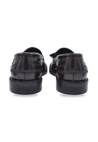 Bruine patenten leren schoenen met een slank ontwerp, ronde neus en een lage zwarte hak. Beschikt over gedetailleerde stiksels en een gladde textuur.