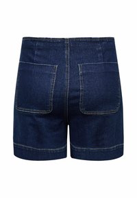 Los pantalones cortos de mezclilla azul oscuro presentan un diseño ajustado con dos bolsillos traseros y un dobladillo limpio, exhibiendo costuras amarillas a lo largo de las uniones.