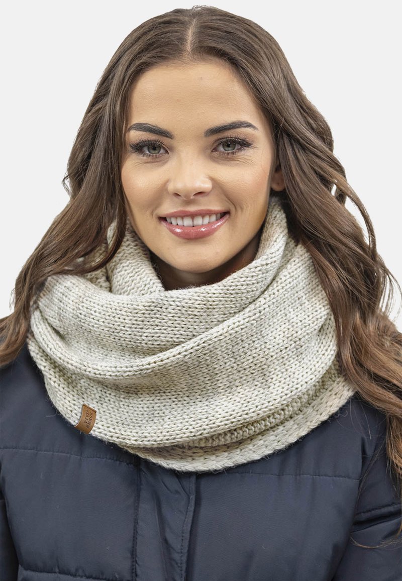 Écharpe en tricot beige en forme d'infini avec un motif texturé et un léger éclat, arborant une petite étiquette en cuir marron d'un côté.