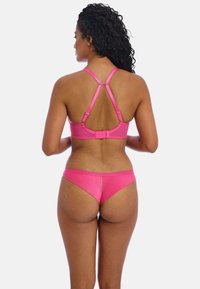 Rosa Bikini-Set mit einem Kreuzruckendesign, metallischem Verschluss und glatter Textur. Der Oberteil hat ein breites Band, und die Unterteile sind tief geschnitten.