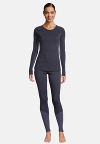 Top a maniche lunghe e leggings in un tessuto grigio scuro elasticizzato con accenti più chiari. Design aderente con texture liscia e senza fantasie.