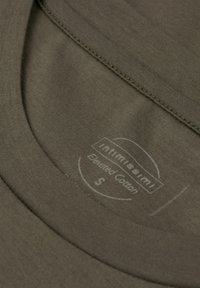 Olivgrünes Baumwoll-T-Shirt mit rundem Ausschnitt und sichtbaren Nähdetails. Verfügt über ein Etikett mit der Aufschrift "Elevated Cotton" in einem kreisförmigen Design.