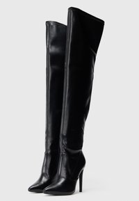 Fekete bőr, térd feletti csizma hegyes orral és magas stiletto sarokkal. Simább textúra és karcsú dizájn, elöl kivágásokkal.