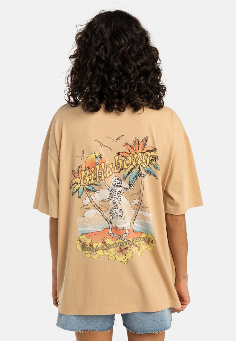 Beige oversized t-skjorte med et grafikk av et skelet mellom palmer, med solnedgang og blomsterdetaljer nederst.
