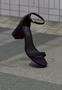 Βιώσιμη μωβ σκούρα γυναικεία σανδάλι με δύο λεπτές λουρίδες και τετράγωνο τακούνι, με χρυσή αγκράφα στον αστράγαλο και λεία υφή.