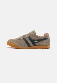 Sneakers in suede beige con strisce blu, suola in gomma color caramello e un accento arancione sul tallone, con il logo "Gola" in giallo sul lato.