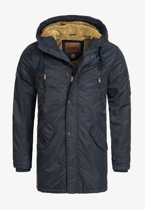 Tengerészkék kapucnis parka bolyhos sárga béléssel, elülső patentos és cipzáras zsebekkel, húzózsinóros kapucnival és struktúrált anyagból készült.