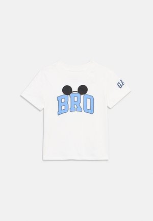 Fehér rövid ujjú póló kék "BRO" felirattal, fölötte fekete Mickey egér fülekkel, valamint a bal ujján "GAP" felirattal.
