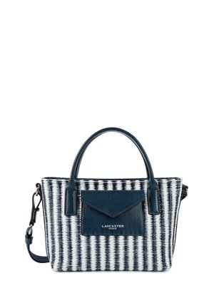 Sac à main tissé bleu marine et blanc avec doubles poignées, poche avant en cuir bleu marine avec rabat en forme d'enveloppe, et bandoulière réglable.