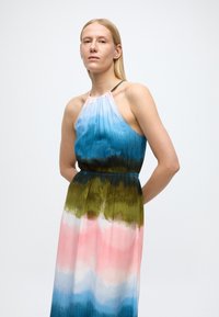 Vestido halter com padrão em degradê nas cores azul, verde e rosa. Confeccionado em tecido leve com design de cintura franzida.