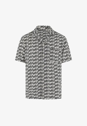 Kurzärmeliges Hemd zum Knöpfen mit durchgehendem diagonalen schwarzen "GUESS"-Logo auf weißem Stoff und einer Brusttasche.