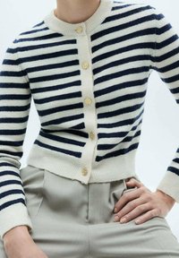 Navy and cream striped cardigan made of soft fabric, featuring a round neck, gold buttons, and a fitted hem.
