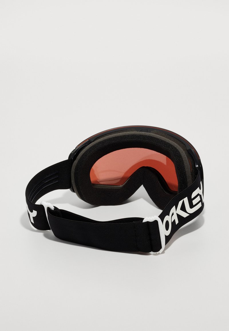 Gafas de esquí negras con lentes naranjas, acolchado de espuma y una cinta elástica negra con un logo blanco. Diseño de lentes curvados para una mejor visibilidad.