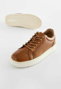 Baskets en cuir brun avec une finition lisse, bout arrondi et semelle en caoutchouc blanche. Présentent des lacets ronds et des détails de design minimalistes.
