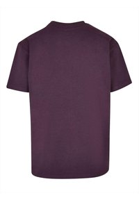 T-shirt en coton violet avec un col ras du cou classique, des manches courtes et un ourlet droit. Le dos est uni sans éléments de design supplémentaires.