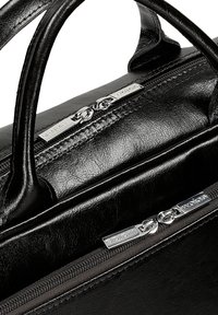 Černá kožená taška s horními uchy, s hladkým povrchem a stříbrným zipovým kováním, na kterém je zobrazeno jméno značky na kovovém štítku.