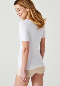 Witte kortempem t-shirt van zacht materiaal, met een ronde halslijn en naadloos ontwerp. Het model toont de achterkant.