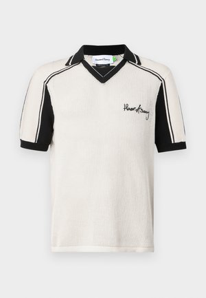 Polo de punto en crema y negro, con cuello en V, mangas cortas, rayas en contraste y logo bordado en el pecho.