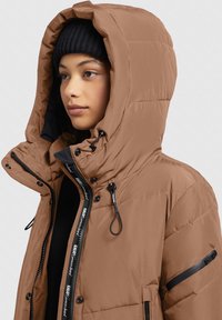 Braune Pufferjacke mit hohem Kragen, verstellbarem Kapuze, Reißverschlusstaschen und schwarzen Akzenten. Hergestellt aus Polyester mit einer glatten Textur.