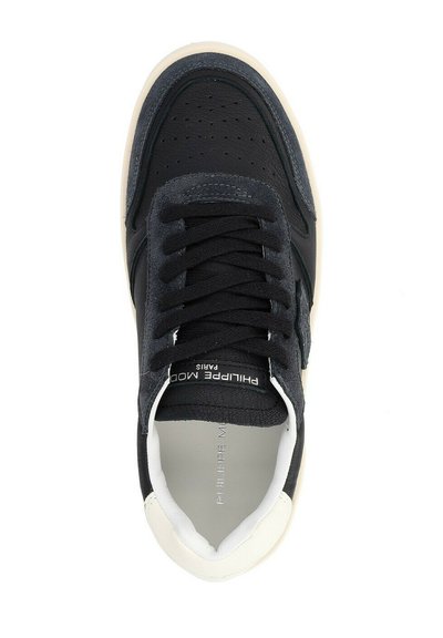 Sneaker nera realizzata in materiali scamosciati e in pelle, con punta rotonda, colletto imbottito, lacci piatti neri, dotata di una suola in gomma bianca e dettaglio del marchio.