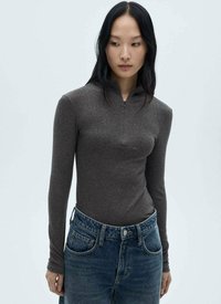 Haut à manches longues zippé gris foncé, en matériau en tricot léger, coupe ajustée, associé à un jean en denim bleu taille haute.