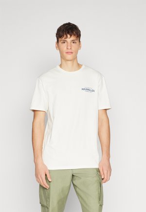 T-shirt blanc à manches courtes avec un col rond, arborant un logo bleu "Wrangler" sur la poitrine gauche, en tissu coton doux.
