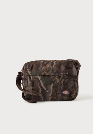 Hnedo-zelená maskáčová crossbody taška s nastaviteľným popruhom a malým logom Dickies na prednej strane.
