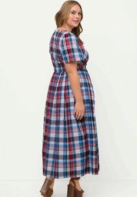 Maxi dress con un motivo a quadri nei colori rosso, blu e bianco. Maniche corte a palloncino e vita aderente con una gonna fluida.