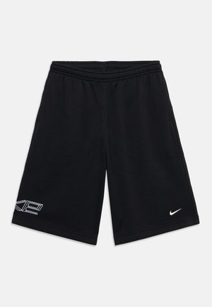 Μαύρο αθλητικό σορτς με ελαστική μέση, λογότυπο Nike στο δεξί πόδι και λευκό γραφικό "XP" στο κάτω μέρος του αριστερού ποδιού.