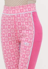 Rosa tights med et geometrisk snøflakmønster, med en strukturert livlinje og kontrasterende sidepanel i ensfarget rosa. Utsmykket med lyseblå sømmer.