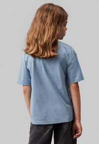 Calvin Klein Jeans MONOGRAM GRID RELAXED - Triko s potiskem - faded denim