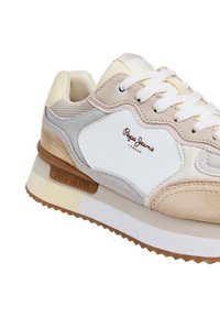 Beige und weiße Pepe Jeans Sneaker mit Schnürdesign, Wildleder- und_mesh-Panels sowie markiertem Sohlen-Detail auf weißem Hintergrund.