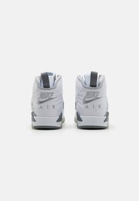 HVITE Nike Air sneakers med grå detaljer, med en polstret design, høy-topps struktur og drahåndtak på hælen for enkel påkledning.