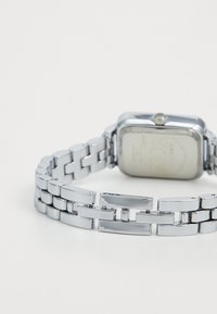 Silberner Metalluhren mit rechteckigem Zifferblatt und Gliederarmband. Verfügt über eine polierte Oberfläche und eine schlichte Krone an der Seite.