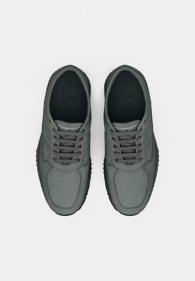 Grå lædersneakers med rund tå, snørelukning, diskret syning og tekstureret sort gummisål. Branding synlig inde i skoen.