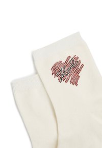 Calze di cotone bianche con strass multicolori disposti a forma di cuore su un lato; bordo a coste nella parte superiore.