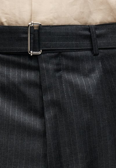 Σκούρο γκρι παντελόνι με λεπτές ρίγες και ζώνη από το ίδιο ύφασμα, στερεωμένη με ασημένια ορθογώνια αγκράφα.