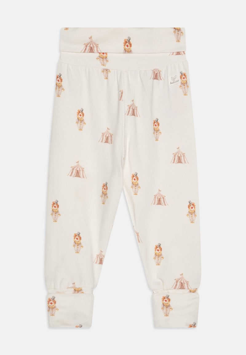 Leggings crème avec une taille élastique, ornés d'un motif de lions et de tentes de cirque. Tissu doux avec des chevilles côtelées.